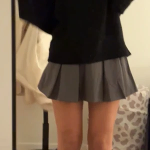 Grå plisserad kortkjol - Snygg grå plisserad kortkjol som ger en stilren look. Perfekt för att matcha med knähöga boots😍Kjolen har insydda shorts vilket är perfekt ifall man böjer sig osv! Aldrig använd bara testat på🩷