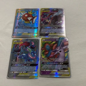 Pokémon GX-kort - Säljer fyra Pokémon GX-kort med holografisk yta. Inkluderar Magikarp & Wailord GX, Gengar & Mimikyu GX, Giratina & Garchomp GX, och Espeon & Deoxys GX. Perfekt för samlare eller spelare som vill förstärka sin kortlek med kraftfulla kort.