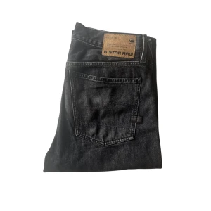 G-Star Raw Type 49 - Mörk Grå - Gråa jeans från G-Star Raw med klassisk femficksdesign. De har en rak passform med läder patch på baksidan.     Orginal pris: 1300kr