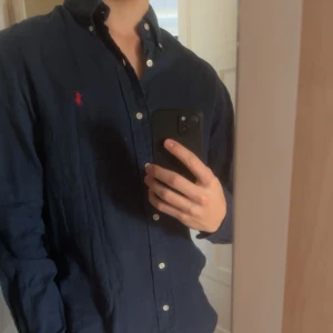 Ralph Lauren Linneskjorta Herr  - Riktigt snygg linneskjorta i storlek S, custom fit, passar mer som M-L skulle jag säga. Skjortan är i mycket bra skick, inga defekter. Skriv vid minsta fundering!