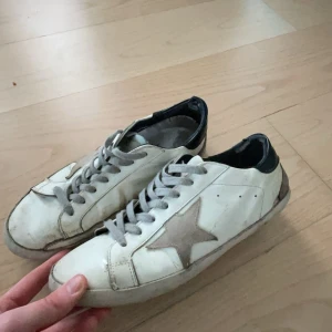Golden goose strl 42 - Tja, säljer ett par vita golden goose skor i strl 42. De är i ganska använt skick därav det billiga priset på dom. OBS, det finns små hål i sulan som syns på de två sista bilderna, men går säkert att laga. 
