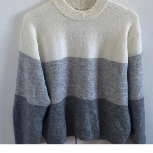 Stickad tröja  - Stickad tröja oanvänd med lappen kvar i strl XS men lite oversize från h&m. Tröjan är offwhite/vit, ljusgrå melerad, lite mörkare grå melerad. Köparen betalar frakten!