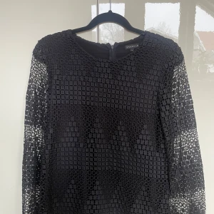 Svart blus i spets - Långärmad svart blus med rutig spets