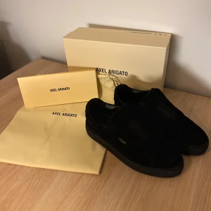 Svarta sneakers från Axel Arigato - Snygga svarta sneakers från Axel Arigato i mocka. De har en stilren design med en diskret logga på sidan. Perfekta för en minimalistisk look. Köpt för 2500 kr 