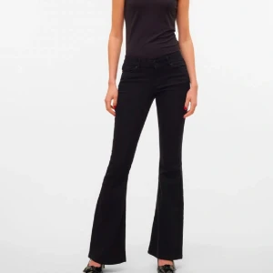 Svarta bootcut jeans - Snygga svarta bootcut jeans med låg midja och klassisk femficksdesign. Perfekta för en stilren look, dessa jeans har en smickrande passform som vidgar sig vid anklarna. Tillverkade i ett bekvämt material som ger en skön känsla hela dagen.