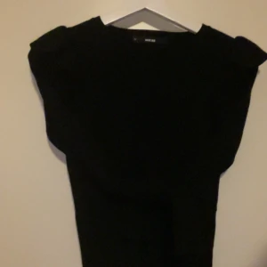 Svart stickad tröja från bik bok  - Elegant svart stickad tröja från bik bok med fin  design. Perfekt för en höst look. Tröjan har en sött detalj vid axlarna som ger det lilla extra.