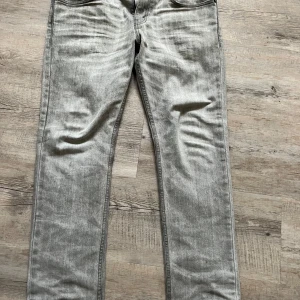 Grå jeans från Levi's - Snygga grå jeans från Levi's med klassisk femficksdesign och en diskret tvättad look. Perfekta för en avslappnad stil. Levi's logotyp syns på bakfickan.