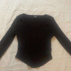Svart ribbad topp från SHEIN - Snygg svart ribbad topp från SHEIN i storlek XS. Toppen har en fyrkantig urringning och långa ärmar, tröjan är helt oanvänd och är i nytt skick. Tröjan är midjekort och är i storlek XS💗💗💗💗