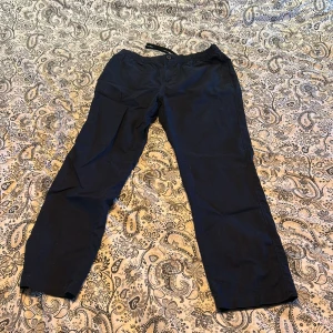 Mörkblåa linnebyxor  - Säljer ett par svarta linnebyxor med dragkedja och snörning i midjan. Byxorna har en avslappnad passform och är perfekta för en bekväm stil. De är tillverkade i ett mjukt material som ger en skön känsla.