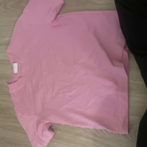 Rosa t-shirt från Gina Tricot - Säljer en rosa t-shirt från Gina Tricot, basically basics-kollektionen. T-shirten har korta ärmar och en klassisk rund halsringning. Perfekt för en avslappnad stil.