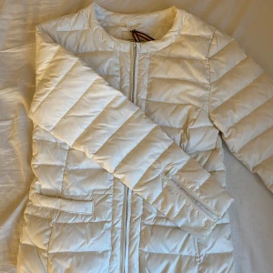 Vit tunn puffar jacka  - Säljer denna vita puffar jacka från Lindex. Liknar den trendiga uniqlo jackan, stolek XS. Den är lite litectrasog vid ena fickan men ingenting som syns eller påverkar fickas funktion. 250kr