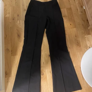 Svarta kostymbyxor från Gina Tricot - Snygga svarta kostymbyxor från Gina Tricot i storlek XS. Byxorna har en klassisk design med medelhög midja. Perfekta för en stilren look.