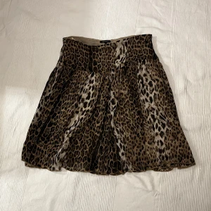 Leopardmönstrad kjol - Snygg leopardmönstrad kjol köpt secondhand. Väldigt bekväm med ett följsamt tyg. Storlek 42/l men skulle säga att den passar s/m bäst beroende på önskad passform