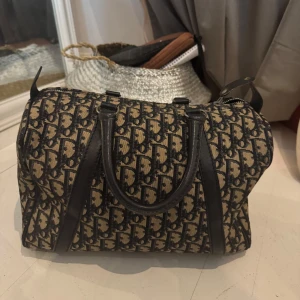 Dior Boston Trotter Väska - Säljer min älskade vintage Dior väska, toppen skick utan några synliga defekter, perfekt storlek till vardags då den är väldigt rymlig.                       Mått:•	Höjd: 20 cm 	•	Djup: 17 cm 	•	Längd: 31 cm 	•	Handtagslängd: 8 cm