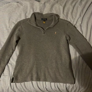Grå tröja från Polo Ralph Lauren - Säljer en stilren grå tröja från Polo Ralph Lauren med dragkedja vid halsen och ett broderat logotypmärke på bröstet. Perfekt för en avslappnad och snygg look. Den är L i barn storlek så passar liten xs men mer xxs, passar inte 14-16 mer 12-14 självklart kan priset diskuteras 