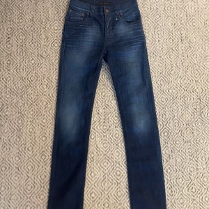 Nudie Jeans - Säljer ett par Nudie jeans som har en väldigt snygg och unik tvätt. Jeansen är i väldigt bra skick utan några tecken på användning. Storleken på jeansen är W27/L32. Vid frågor eller funderingar är det bara att höra av sig👍