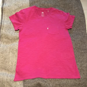 Rosa t-shirt från Levi's - Säljer en snygg rosa t-shirt från Levi's i storlek XS. T-shirten har en bröstficka och är tillverkad i mjukt material. 💕