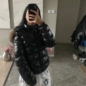 Svart dunjacka från Moncler - Säljer min snygga pufferjacka i dun från Moncler. Pälsen går att ta av med dragkedja (se bild 4) . Storleken är 11-12 år men passar mig som är 17 år, 165cm och brukar bära XS/S. Jackan har två små hål över vardera fickor (se bild 5), men går att fixa enkelt genom att sy eller ta till skräddare, därav det billiga priset, annars är jackan i nyskick. Man kan även scanna QR koden i jackan! ❤️