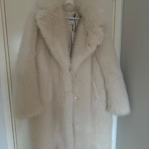 pälsjacka coat faux fur bershka zara hm - Säljer en lyxig vit pälsjacka från Bershka. Jackan har en fluffig och varm design med långa ärmar och knappar framtill. Perfekt för att hålla sig varm och stilren under kalla dagar. Storlek L. Ny med prislapp. Nypris 1195kr