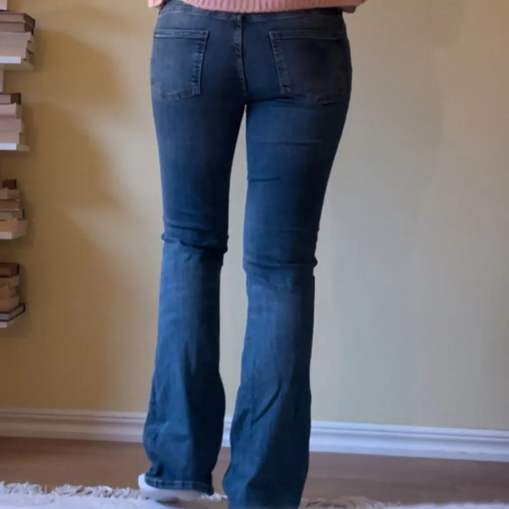 Lågmidjade blå bootcut jeans. Midja: 36cm Innerbenslängd: 77,5cm. Farkut & Housut.