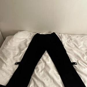 Svarta opium byxor  - Snygga opium svarta byxor. De har en modern design med justerbara remmar vid anklarna. Perfekta för en stilren look och jag har inte använt dem så mycket.