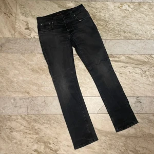 Nudie Jeans - Snygga svarta jeans från Nudie Jeans med klassisk femficksdesign och knappgylf. Perfekta för en stilren look. W30 L32 modell Grim Tim (den populäraste✨). Skriv vid minsta fundering 