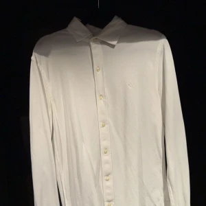 Vit skjorta från Ralph Lauren - Klassisk vit skjorta från Ralph Lauren med långärmad design och knappar framtill. Perfekt för en stilren look. Tillverkad i ett mjukt och bekvämt material.