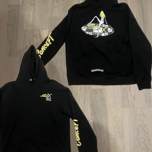 Chrome Hearts x Matty Boy Hoodie - Säljer en svart hoodie från Chrome Hearts med tryck på ryggen och ärmen. Hoodien har en cool design med textdetaljer och en stor grafisk bild på baksidan. Perfekt för en avslappnad stil. 