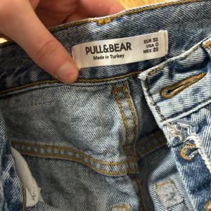 Blå jeans från Pull&Bear - Säljer ett par klassiska blå jeans från Pull&Bear. De har en knappgylf och en snygg, avslappnad passform. Perfekta för en casual look.