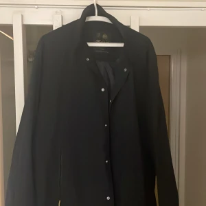 Mörk kappa/coat från Morris *förhandlingsbart pris* - Stilren kappa från Morris som sitter bra om man är lite längre. Nyligen inköpt och kan räkna på en hand hur många gånger den är använd. Säljer på grund av konkurrensen som finns i garderoben. Mycket bra kvalitet på materialet som skyddar bra mot regn, den alltså både praktisk och snygg. Dyr men kan såklart förhandla