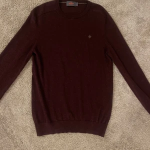 Morris tröja - Säljer en stilren vinröd tröja från Morris i 100% merinoull. Tröjan har långa ärmar och en diskret logga på bröstet. Perfekt för kyligare dagar. Medium men passar small 