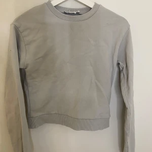 Grå sweatshirt NA-KD - Säljer en fin grå/blå sweatshirt från NA-KD collab med Pamela.  Har använts men är som i nyskick så bra kvalitet. Köpt här på plick, tveka inte att skriva för fler bilder eller om du har frågor 🤍🥰