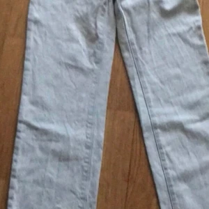 Ljusblå jeans från Tommy Hilfiger stl 164 - Säljer ett par ljusblå jeans från Tommy Hilfiger. De har en klassisk femficksdesign och en diskret logga på bakfickan. Perfekta för en avslappnad stil.