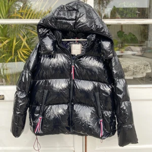 Tommy Hilfiger Palmer Glossy Down Jacket - Tommy Hilfiger dunjacka i glansig svart färg. Enormt snygg, bekväm och praktisk. Orderbekräftelse finns. Nypris 3100kr. Strl L. Använd men i bra skick utan skador. Unisex, funkar bra för både kille & tjej. Pris kan diskuteras. Hör av er vid frågor! 