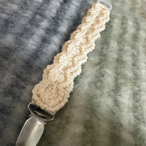 Handgjort virkat bälte - Säljer en unik handgjord virkad napphållare i en krämig vit färg. Napphållaren har en vågig design och är virkat i bomullsgarn. 