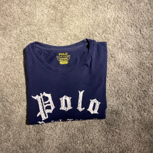 Polo Ralph Lauren T shirt - Hej, säljer en Polo Ralph Lauren t shirt i okej skick. Den har används en del men har fortfarande mycket att ge. En riktig snygg t shirt. Nypris va runt 700kr. Jag säljer den för 249kr. Det är storlek Small. Färg marinblå.  Mvh