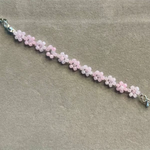 Färgglada pärlarmband med blommor - Säljer superfina handgjort armband med små blommor av pärlor. Finns i flera färger: rosa, blå, vit och gul. Perfekta för att liva upp vilken outfit som helst! Armbanden har en söt och lekfull stil, idealiska för både vardag och fest.