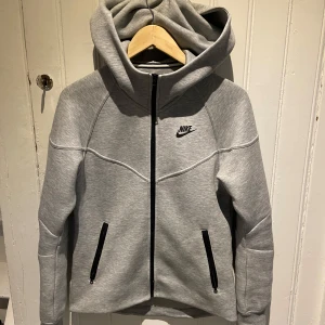 Grå windrunner nike tech fleece herr xs  - Den är i nyskick ock använd max 3 gånger så istortsätt ny säljs pågrund av att den inte kommer till användning, köpt på Nikes egna butik i Barkarby outlet i Stockholm. Nypris 1400kr. Pris kan diskuteras 