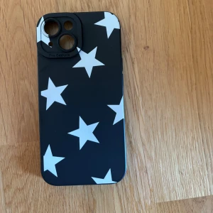 Svart mobilskal med vita stjärnor - Snyggt svart mobilskal med vita stjärnor. Passar iPhone 15.