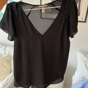 HM blus - Svart lite genomskinlig blus från HM i storlek 38. Knappt använd. Kan både posta och mötas upp och kan även skicka fler bilder om det önskas!💞