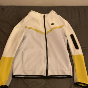 Nike tech - Vit gul nike tech från Nike affären. Vill sälja den för att den är för liten. Storlek 158-170cm