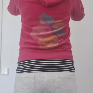 Juicy kofta med tryck i bak - As snygg rosa juicy kofta med tryck i bak, text i fram och guldigt j. Skriv vid frågor