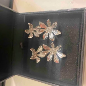 Silvriga blommiga örhängen - Eleganta silvriga örhängen i form av blommor. Perfekta för att ge en glittrig touch till din outfit. De har en vacker design med flera blomblad som fångar ljuset fint.