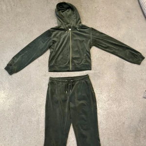Grön hoodie och byxor från Gina Tricot, strl. 146/152  - Velour/plysch set med grön hoodie och matchande byxor från Gina Tricot. Hoodien har dragkedja och långa ärmar, medan byxorna har resår i midjan och bakfickor. Perfekt för en avslappnad stil.