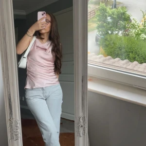 Rosa satinblus - Säljer en elegant rosa blus i satin med draperad halsringning. Perfekt för en stilren look. Blusen har en smickrande passform och är lätt att matcha med olika outfits. Använd två gånger men inget fel kommer ej till användning. Nypris 399kr