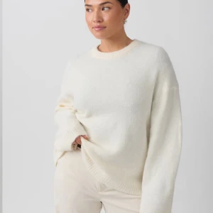 Vit stickad tröja - Säljer en stilren vit stickad tröja med rund hals och långa ärmar. Perfekt för kyligare dagar och enkel att matcha med olika outfits. Tröjan har en mjuk och bekväm passform.