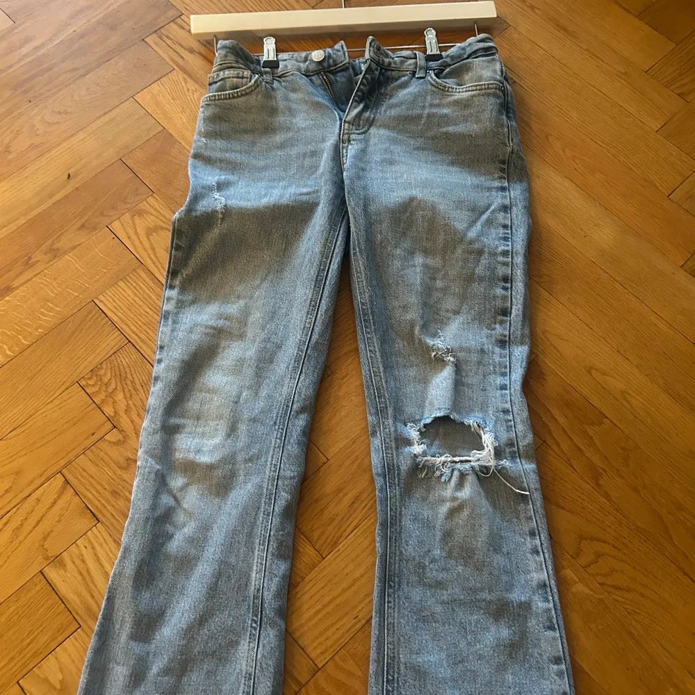 Säljer dessa snygga blåa bootcut jeansen från Gina Tricot med slitningar på benen. Säljer då de inte passar mig längre! Inga större defekter förutom det man kan se på sista bilden. Köpta för ca 2 år sedan men inte jätte använda . Farkut & Housut.