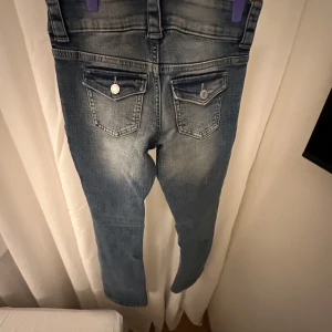 Low waist jeans från H&M - Snygga blå bootcut jeans från H&M med justerbar midja och låg midja. 