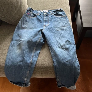 Blå jeans från Big Boy - Säljer ett par klassiska blå jeans från Big Boy med en cool broderad detalj på fickan. Jeansen har en loose passform och är perfekta för en avslappnad stil. De har en högmidjad design och är tillverkade i slitstarkt denim.