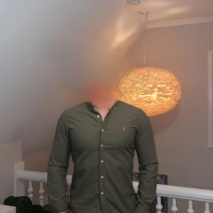 Olivgrön skjorta från Ralph Lauren. Modell slim fit, storlek s. Skjortan är helt i nyskick och har inga som helst deffekter. Tveka inte på att höra av dig vid minsta lilla fråga eller fundering! - Snygg olivgrön skjorta från Ralph Lauren med klassisk krage och knappar framtill. Skjortan har långa ärmar och en liten broderad logotyp på bröstet. Perfekt för en stilren look!